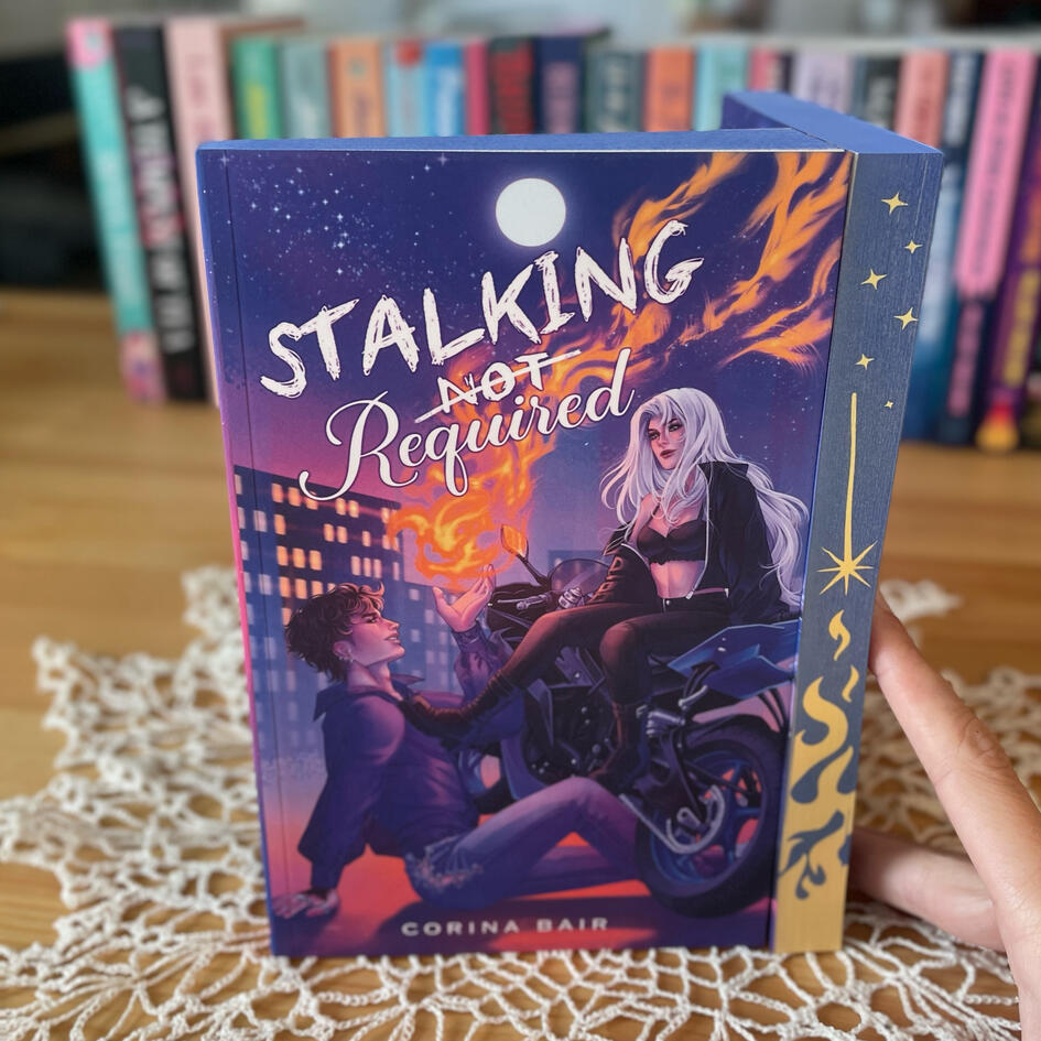 The cover of Stalking -Not-Required: A paranormal romcom by Corina Bair featuring a woman with silver hair sitting on a motorycle. Her booted foot is on a man's chest where he is sitting on the ground, smiling up at her and conjuring a flame in his palm.
